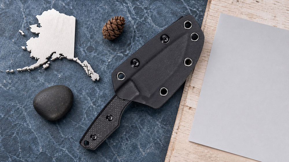 Sheathed black HOPIAN Morrow knife in a neutral Alaska legal research scene