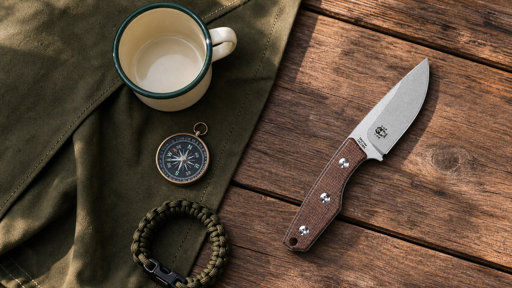 Brown HOPIAN Morrow fixed blade with a camping mug, compass, and paracord