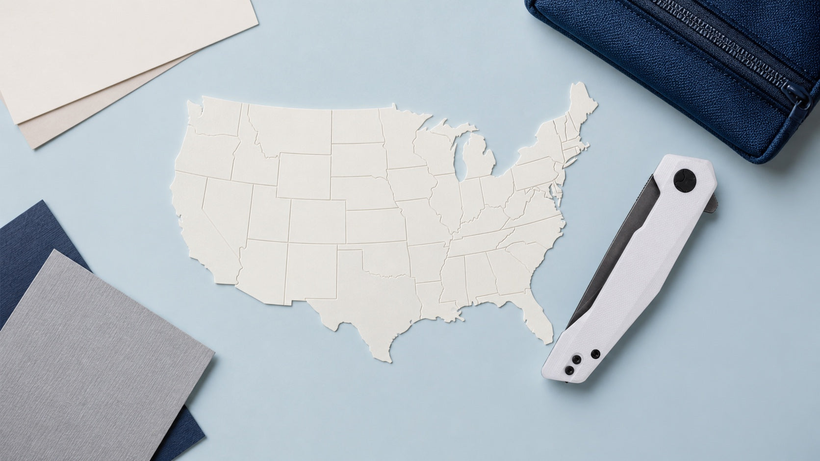 Cuchillo HOPIAN VEX blanco cerrado junto a un mapa en blanco de Estados Unidos