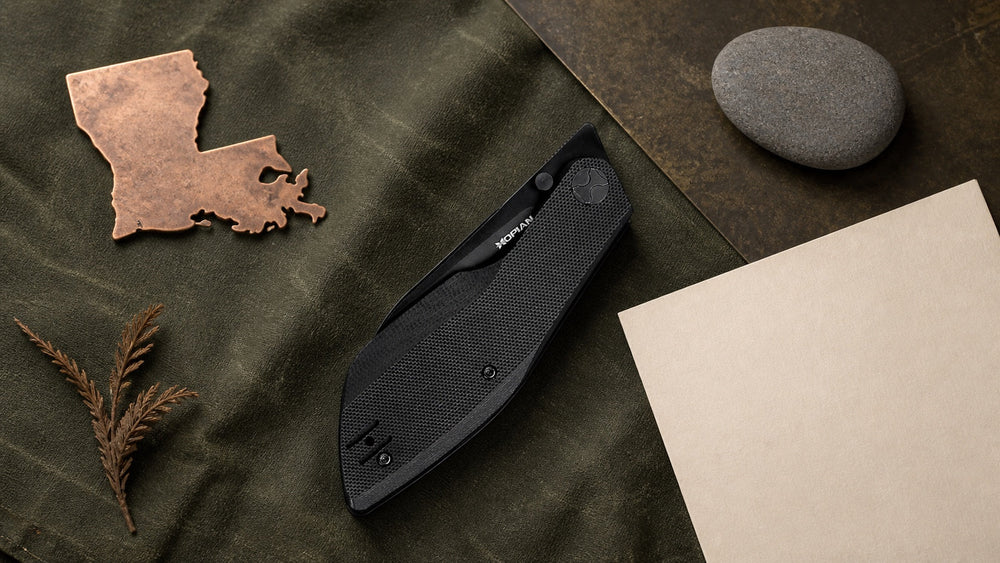 Closed black HOPIAN Periodic knife in a neutral Louisiana legal research scene
