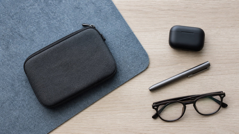 Discreet office EDC pouch, earbuds, pen, and folded eyeglasses