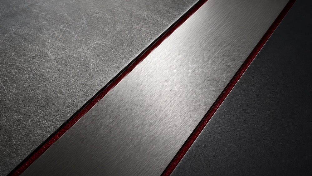 Stonewashed, Satin und schwarze PVD Metalloberflächen im Vergleich unter gerichtetem Licht